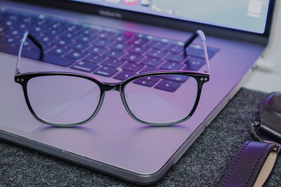 Stylish blue light glasses displayed on a sleek wooden table in Okotoks, Alberta.